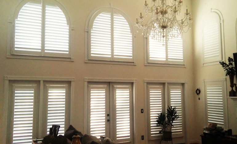 TV room in open concept Atlanta house with plantation shutters on high ceiling windows.