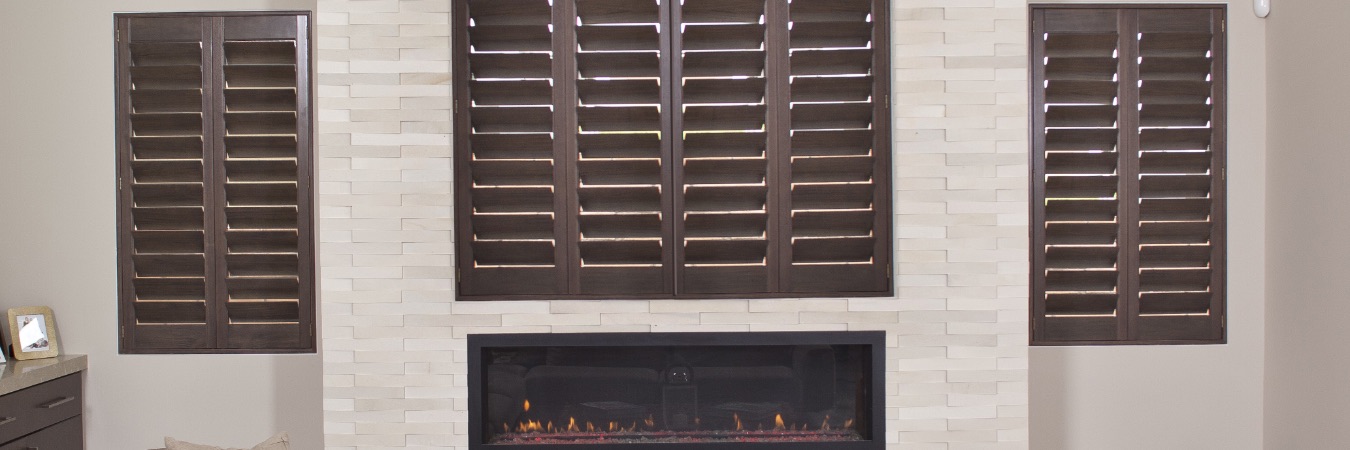 Ovation wood shutters by a fireplace