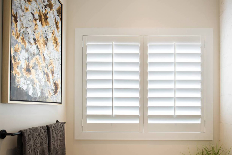 White Polywood shutters in a small bathroom full of light.