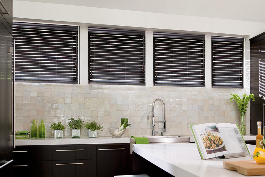 Choose custom Polywood faux wood blinds for your kitchen in Atlanta. Special shaped faux wood blinds in several windows above a sink.