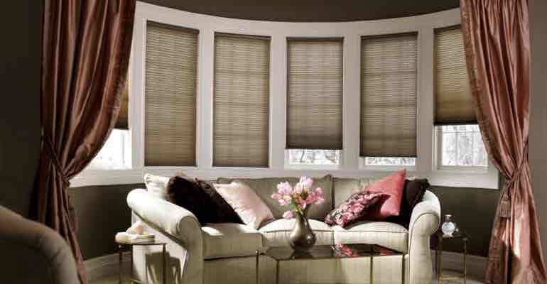 Vertical honeycomb shades in parlour bow window.