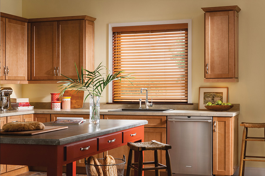 Waterproof faux wood blinds are durable and give you privacy and light control in your Atlanta kitchen. Dark faux wood blinds above a kitchen sink