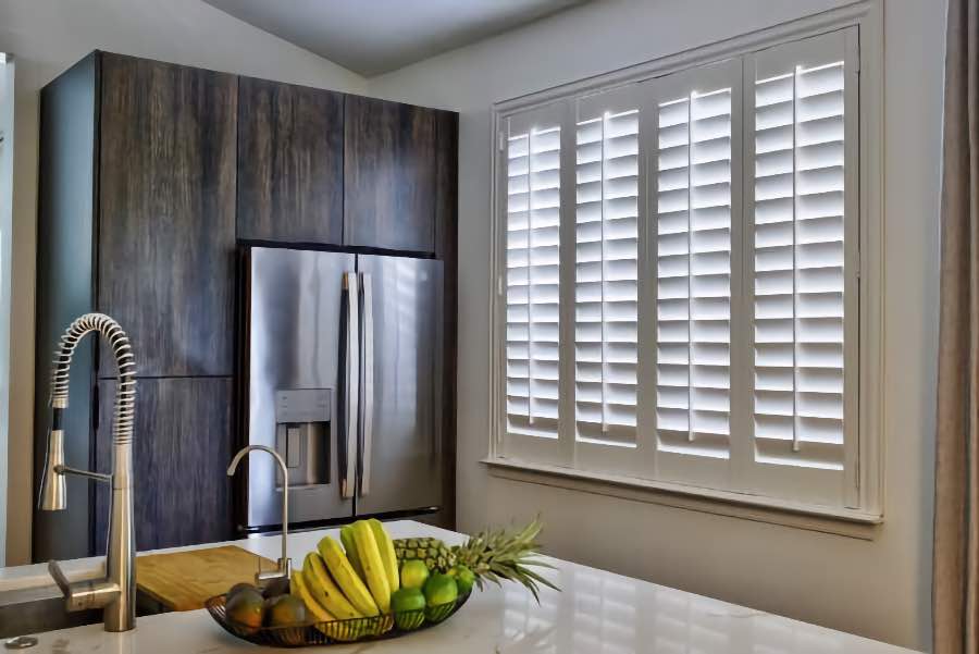 Homeowners use indoor window shutters in Atlanta when they want attractive and functional window treatments. Polywood shutters on a large kitchen window