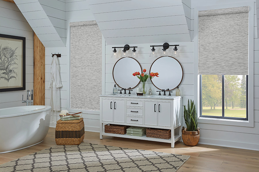 Slim-profile roller shades easily fit shallow windows in your Atlanta home. Gray patterned roller shades on bathroom windows
